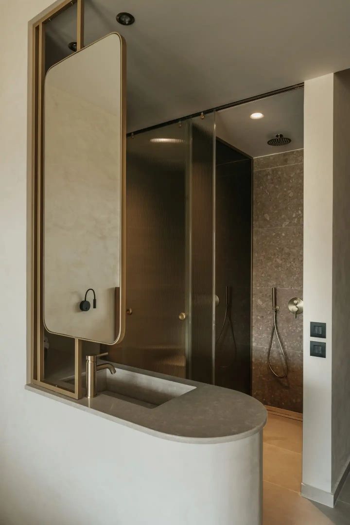 Moderner Waschtisch und verglaste Regendusche in Erdtönen im Badezimmer.