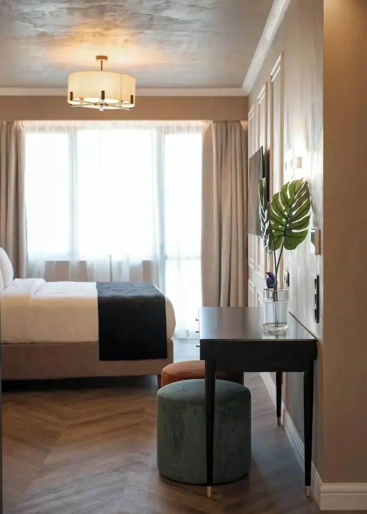 Helles Hotelzimmer mit Doppelbett, Parkettboden und einem modernen Schreibtisch.
