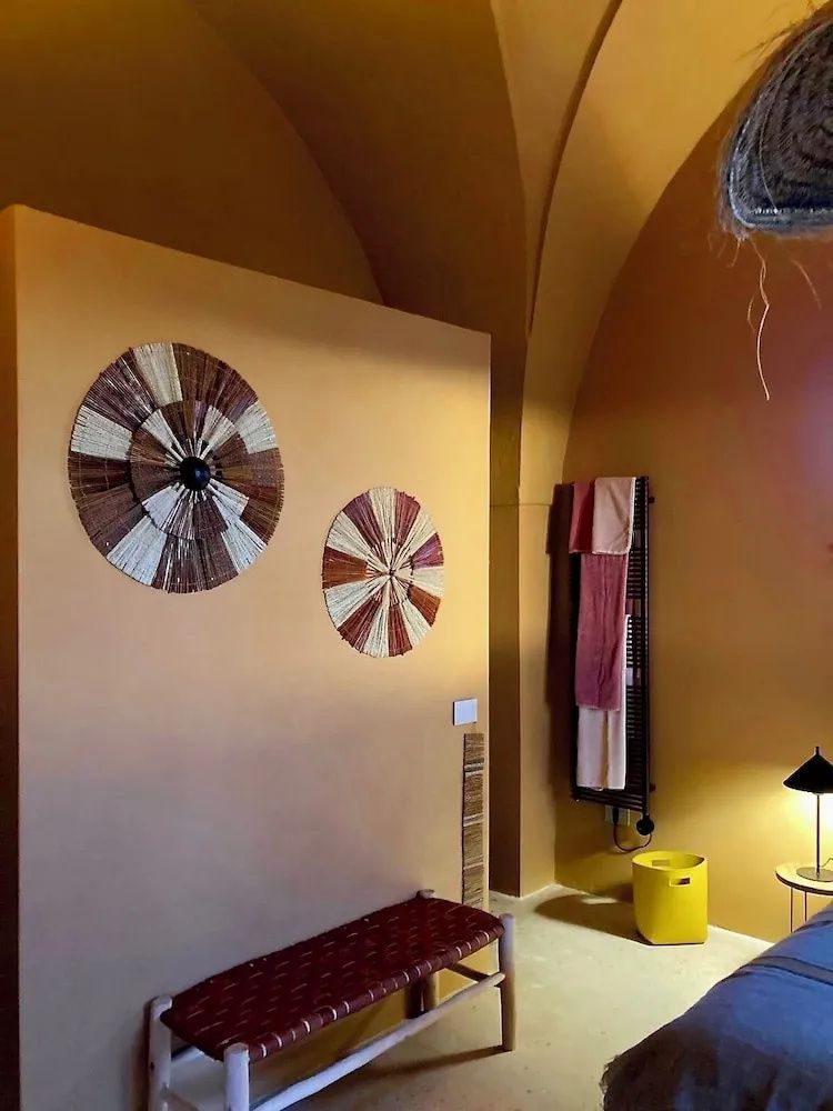 Zimmerecke mit runden Wanddeko Elementen aus Stroh und warmen terracottafarbenen Wänden.