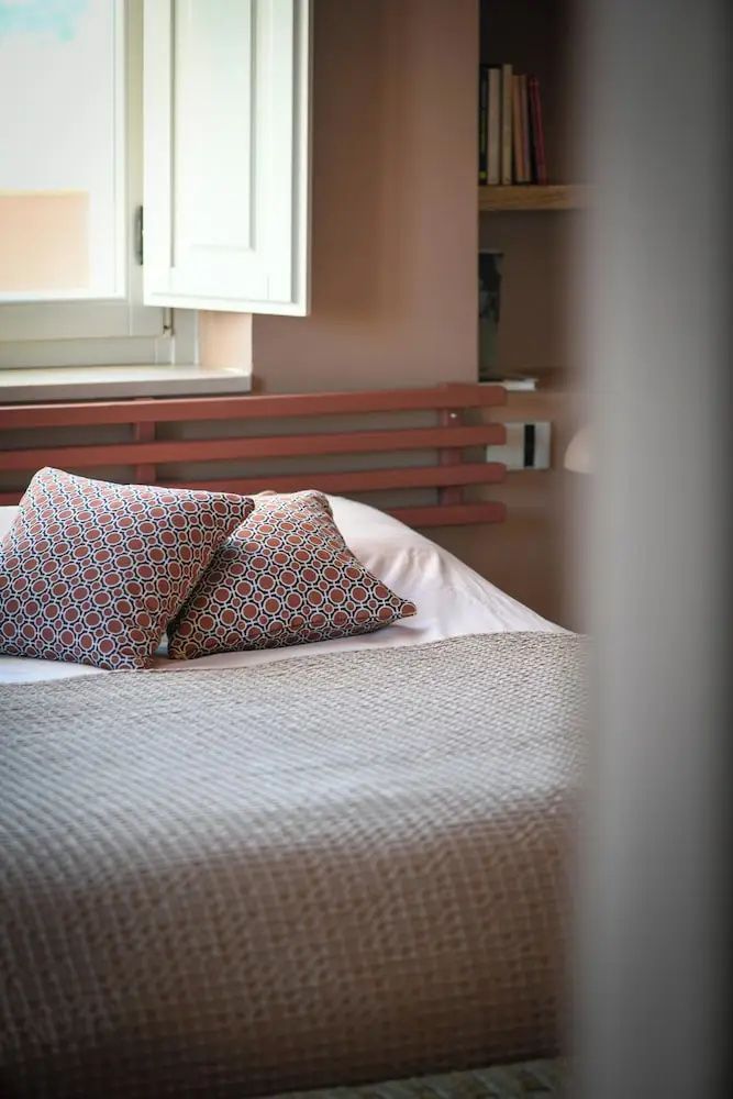 Nahaufnahme von zwei gemusterten Kissen auf einem Doppelbett im Hotelzimmer.