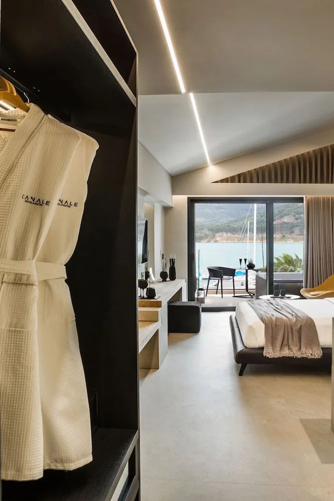 Helles Hotelzimmer mit Doppelbett, Balkonzugang und Blick auf die Bucht.