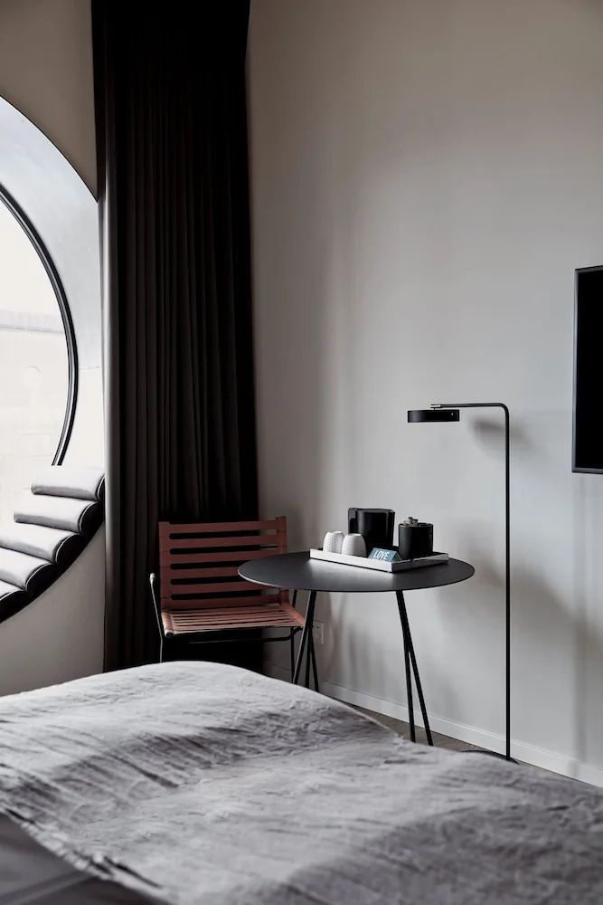 Sitzecke im Zimmer mit schwarzem Tisch, Kaffeetablett, Stuhl und einer Stehlampe.