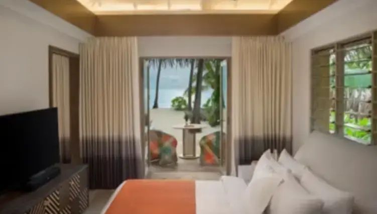 Blick aus dem Schlafzimmer über die Terrasse auf den Sandstrand und das Meer.