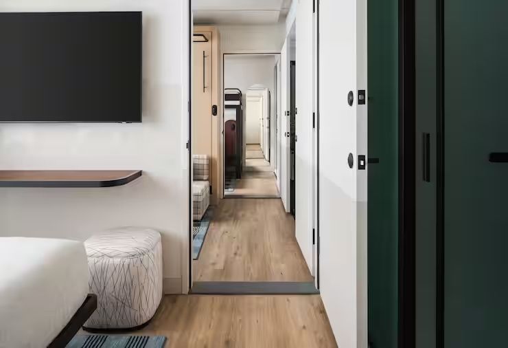 Blick durch geöffnete Verbindungstüren zwischen mehreren Hotelzimmern.