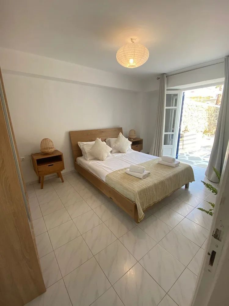 Schlafzimmer mit einem Holzdoppelbett und Zugang zur eigenen Terrasse.