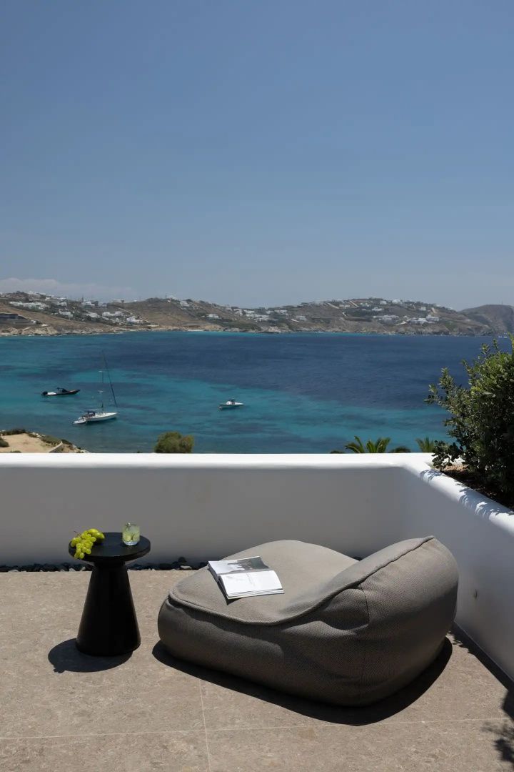 Terrasse mit Sitzsack und Beistelltisch mit freiem Blick auf die Meeresbucht.