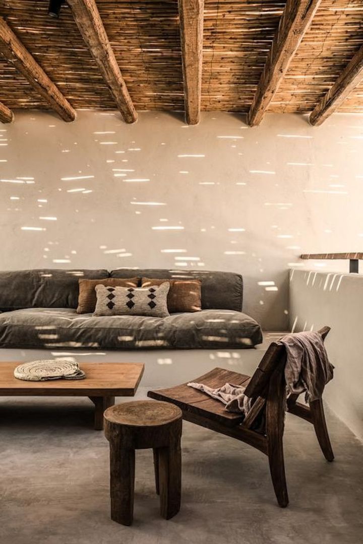 Überdachte Terrasse mit Holzdecke, grauem Sofa, Holztisch und Holzstuhl im Sonnenlicht.