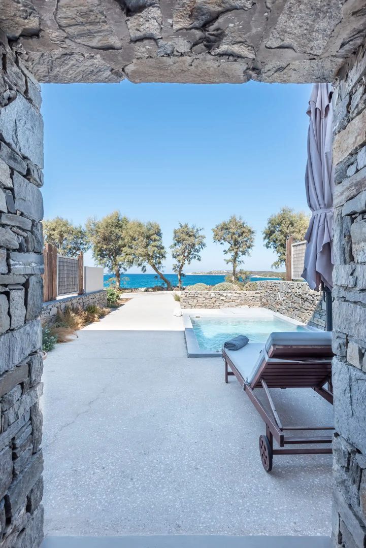 Terrasse mit kleinem Pool, Liegestuhl und Blick auf das Meer und Bäume.