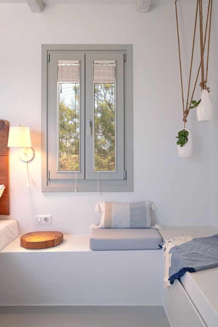 Helles Zimmer mit gemütlicher Sitznische am Fenster und feinen Dekorationen.