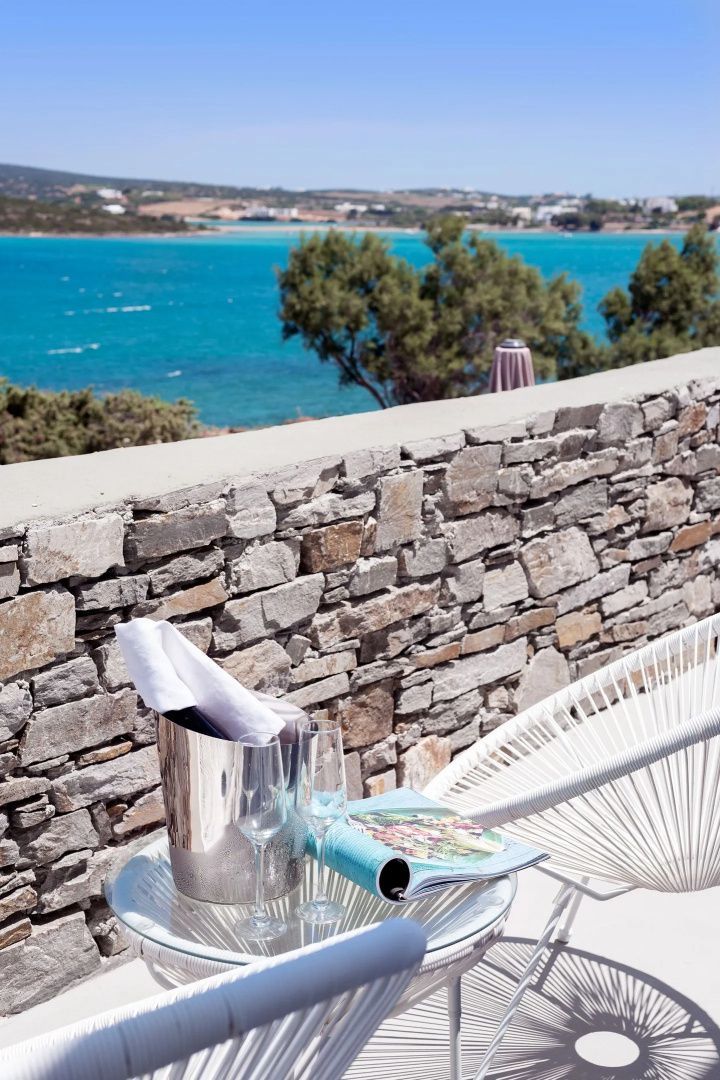 Blick von der Terrasse über eine Natursteinmauer auf das türkisblaue Meer.