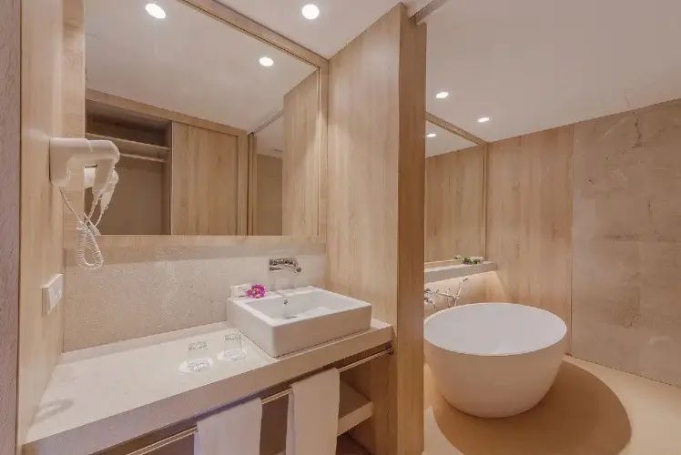 Badezimmer in Holzoptik mit rechteckigem Waschbecken und freistehender Wanne.