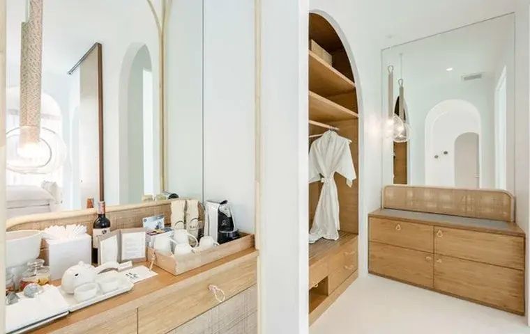 Ankleidebereich und Minibar aus hellem Holz in einer minimalistischen Suite.
