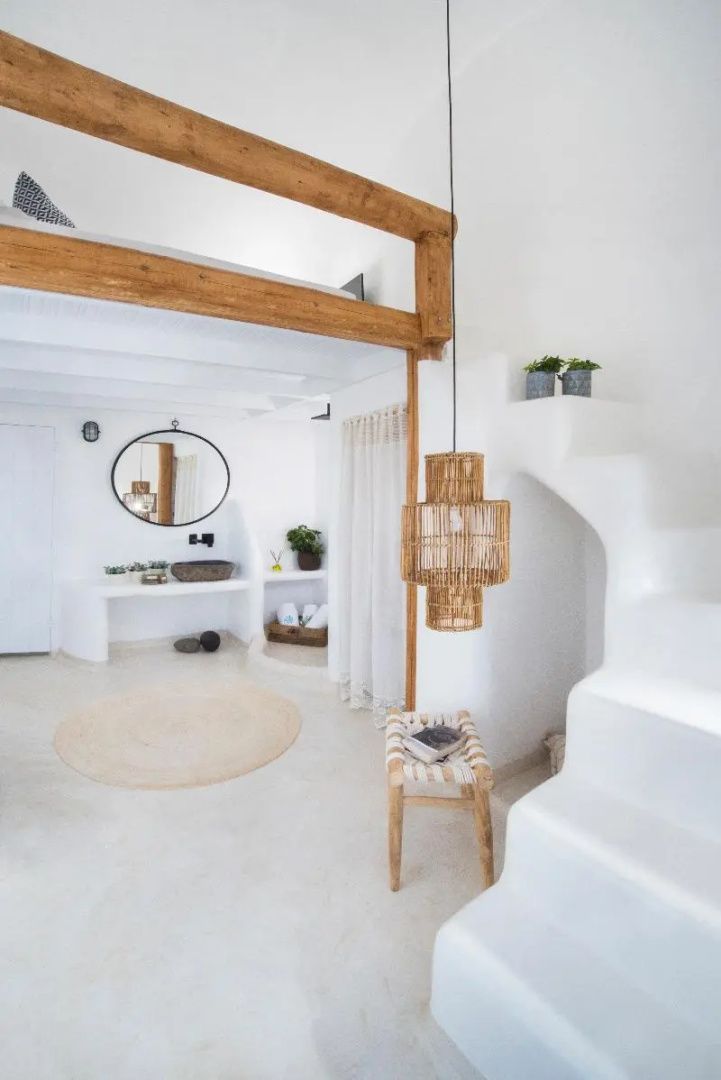 Heller Wohnbereich im traditionellen Stil mit Holzbeplankung, weißer Treppe und Spiegel.