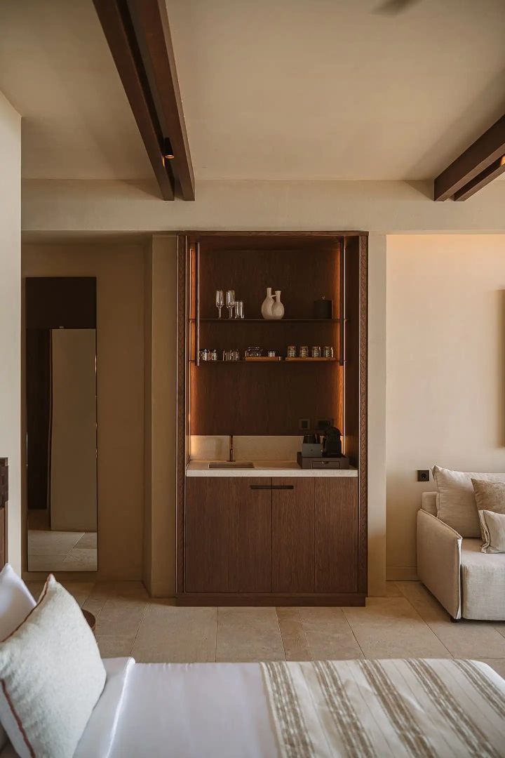 Wohnbereich mit integrierter Minibar aus Holz, Kaffeemaschine und Sofa