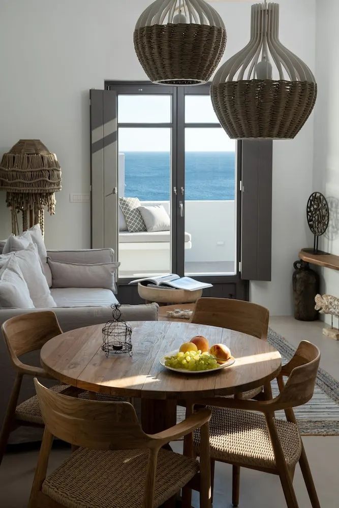 Wohnbereich mit Holztisch und geöffneter Balkontür mit Blick auf das Meer.