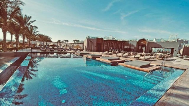 Großer Pool mit Liegen und Sonnenschirmen unter blauem Himmel im Sunrise Tucana Resort in Makadi Bay am Roten Meer