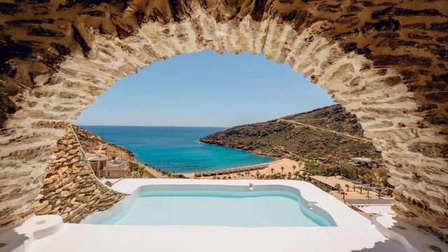 Steinbogen mit Blick auf die Bucht von Papas Beach und den Pool des Calilo auf Ios