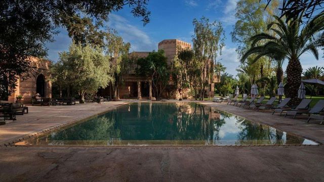 Langer Pool zwischen Palmen und Olivenbäumen im Garten der Villa Al Assala in der Palmeraie von Marrakesch